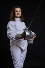 Teenage girl fencer dressed in uniform with epee and helmet