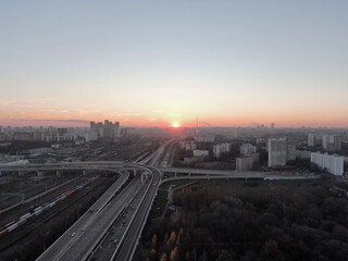 Aerial view panorama of multi-level transport interchange in the center of the big city at dawn. Beautiful panoramic landscape infrastructure of modern city from great height