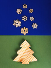 The zero waste new year concept as a handmade wooden fir tree and falling wooden snowflakes on the blue and green background.