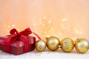 christmas background with bokeh lights, golden christmas balls and red gift box