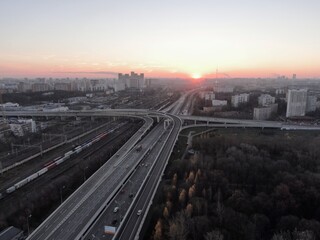 Aerial view panorama of multi-level transport interchange in the center of the big city at dawn. Beautiful panoramic landscape infrastructure of modern city from great height