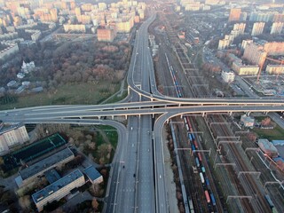 Aerial view panorama of multi-level transport interchange in the center of the big city at dawn. Beautiful panoramic landscape infrastructure of modern city from great height
