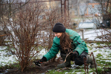 Caucasian cute woman gardener with garden tool close up, gardener pruning branches with pruning...