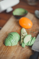 Pieces of avocado and tomato vegetables on a cutting wooden board