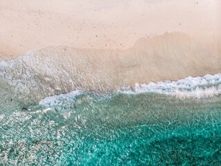 Fototapeta na wymiar Aerial view of clear sea waves and white sandy beaches in summer.