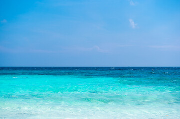 Clear sea waves and white sandy beach in summer.