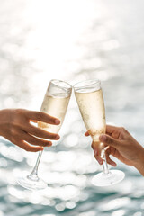 Hand holding a glass drinking wine on Sunset sea background. © satit