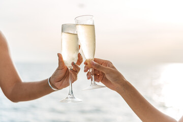 Hand holding a glass drinking wine on Sunset sea background. © satit