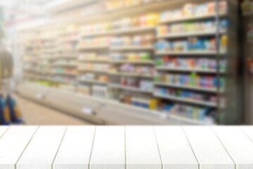 Wood table top with blur supermarket in background; can be used for display or montage your products.