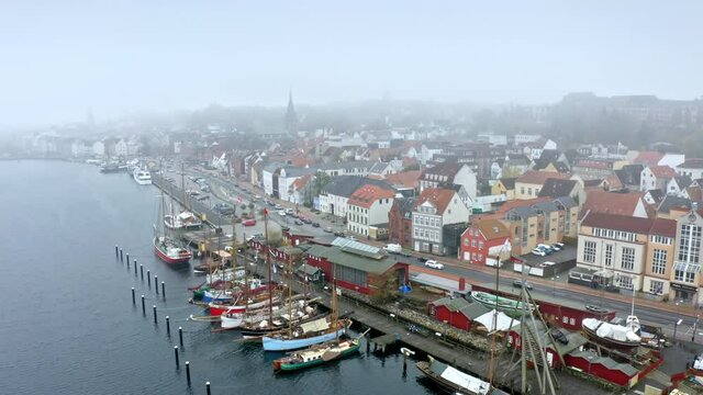 Drone flight over foggy Flensburg port and the small town overview, Germany