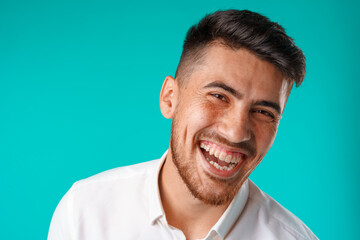 Young positive european man standing in blank white shirt laughing