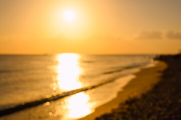 Sunset over the seashore. Background on the theme of the sea and nature. Image is out of focus