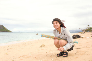 One teen girl on Hawaiian beach exploring in sand