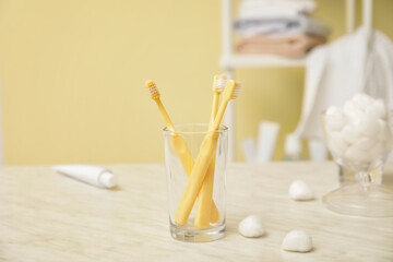 Fototapeta premium Holder with toothbrushes on table in bathroom