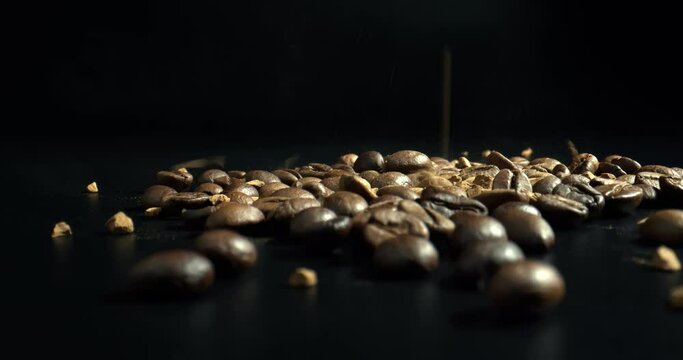 Coffee beans with falling down Instant coffee. Close-up Slow motion shot of coffee on black background. High quality 4k footage