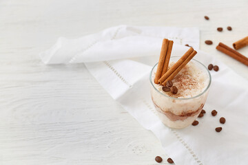 Glass of tasty rice pudding with cinnamon on light table