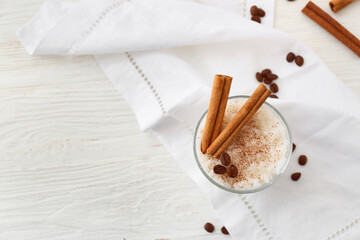 Glass of tasty rice pudding with cinnamon on light table