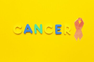 Word CANCER and golden ribbon on color background