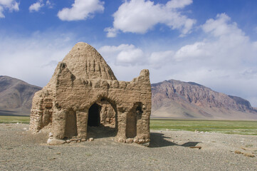 Landscape view of old caravanserai or Chinese tomb surrounded by mountains at Bash Gumbaz near Alichur, Gorno-Badakshan, Tajikistan Pamir - obrazy, fototapety, plakaty