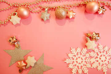 Christmas background with golden balls and snowflakes. Christmas decorations on pink background. 