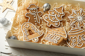 Box with Christmas cookies on white wooden background
