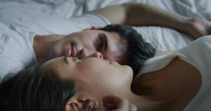 Cinematic close up shot of young couple in love is relaxing in the bedroom in the early morning in a sunny day.