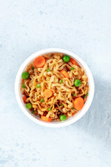Ramen cup with vegetables, overhead shot with a place for text. Instant noodles