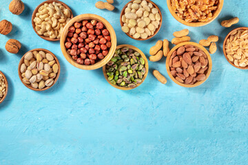 Nuts assortment, shot from the top with a place for text on a vibrant blue background