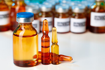 Pile of glass medical vials with medication on lab table