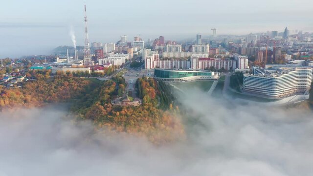 Aerial Flight view over Monument to Salavat Yulaev with Congress Hall, Television tower, forest and city buildings in the fog. High quality 4k footage