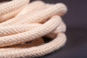 macro photo of new beige shoelaces with on a black background