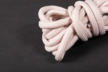 new beige shoelaces with plastic lace cap on a black background