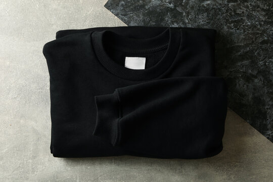 Black Folded Sweatshirt On Two Tone Background