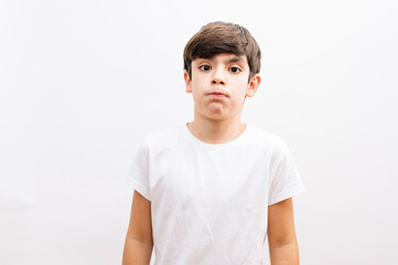 Beautiful kid boy wearing casual t-shirt standing over isolated white background puffing cheeks with funny face. Mouth inflated with air, crazy expression.
