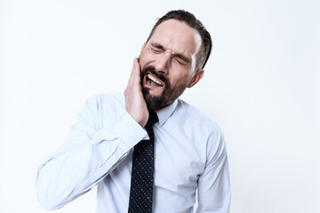 A man twists his face and feels severe pain.