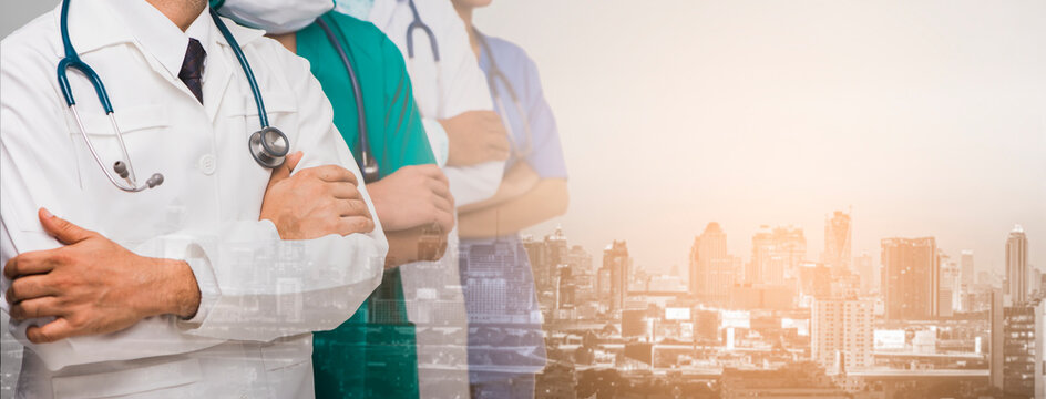 Advertising, Hospital, Profession and Medicine Concept - Cropped image of Team of doctors and nurses with stethoscopes and background blur building skyscrapers at sunset. Panorama