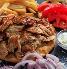 Gyros grilled meat slices on a pita bread, closeup view