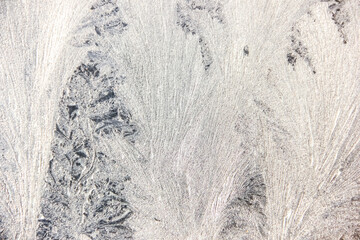Texture of blue frost on a glass window. Frosty cold weather. White ice patterns texture close-up....