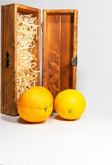 oranges in a wooden decorative box on a white background