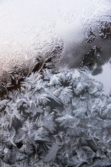 Texture of blue frost on a glass window. Frosty cold weather. White ice patterns texture close-up. New year and Christmas background