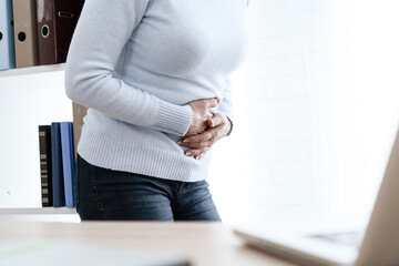 Woman in strict clothes and severe abdominal pain.