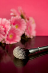 Obraz na płótnie Canvas Makeup powder brush and gerbera flowers