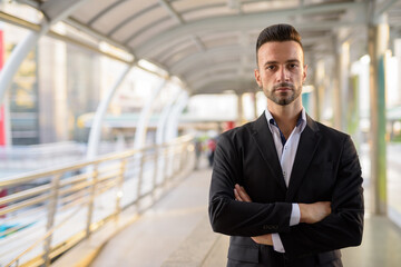 Fototapeta premium Confident businessman outdoors in city with arms crossed
