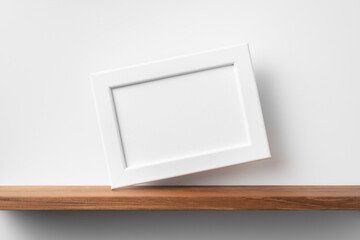 horizontal white wood photo on bookshelf and wall