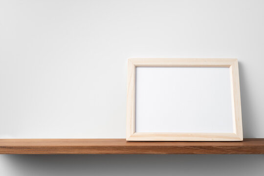 horizontal brown wood photo on bookshelf and wall