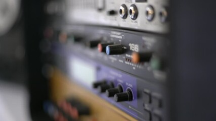Close up of audio recording device with knobs and switches. Equalizer and headphone amp. Smooth sliding camera movement with shallow depth of field. Shot in 4K.