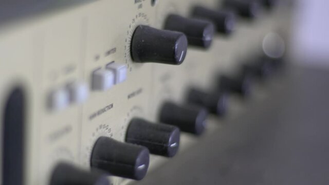 Close Up Of Knobs And Switches On A Audio Recording Device. A Headphone Amplifier. Smooth Sliding Camera Movement With Shallow Depth Of Field. Shot In 4K.