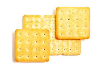 Saltine or soda crackers lightly sprinkled with coarse salt on a white background. Square biscuits on the table. Morning breakfast snack. Wheat light meal snack in lunch time. Salty cookies.