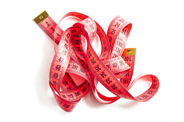 Red measuring tape curls on a white background isolated. Tailor's sewing cloth measuring tool....