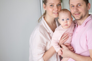 Portrait of happy young parents with baby at home